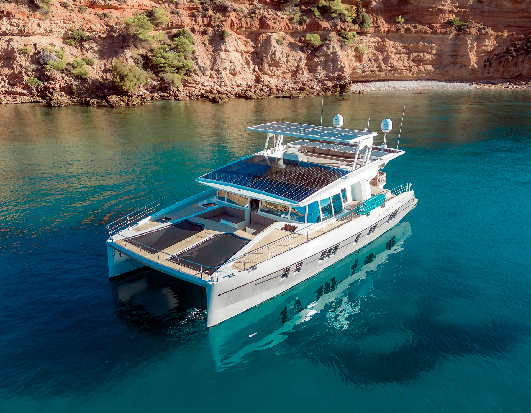 Silent yacht with solar panels on the roof in crystal clear water